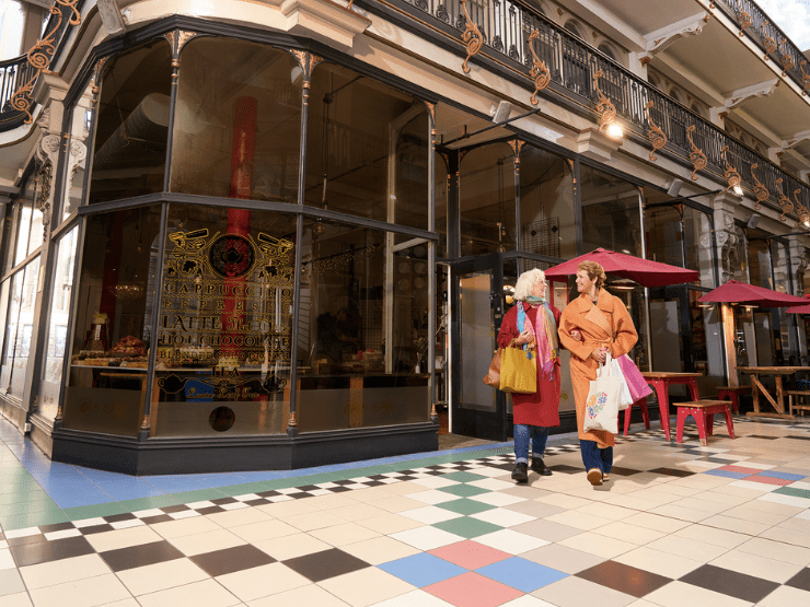 Two friends in a shopping centre leaving a shop 
